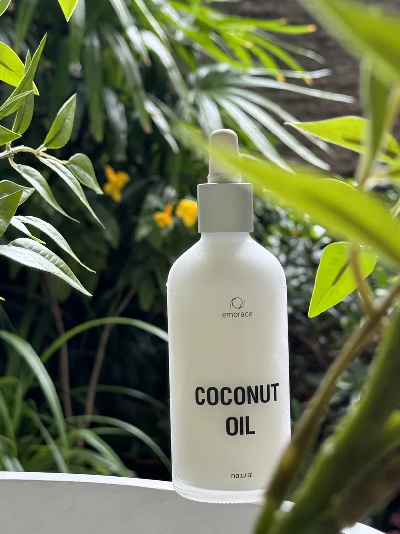 Embrace coconut oil among green leaves