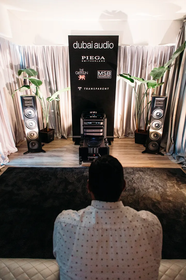 A visitor in the listening chair before a dubai audio system