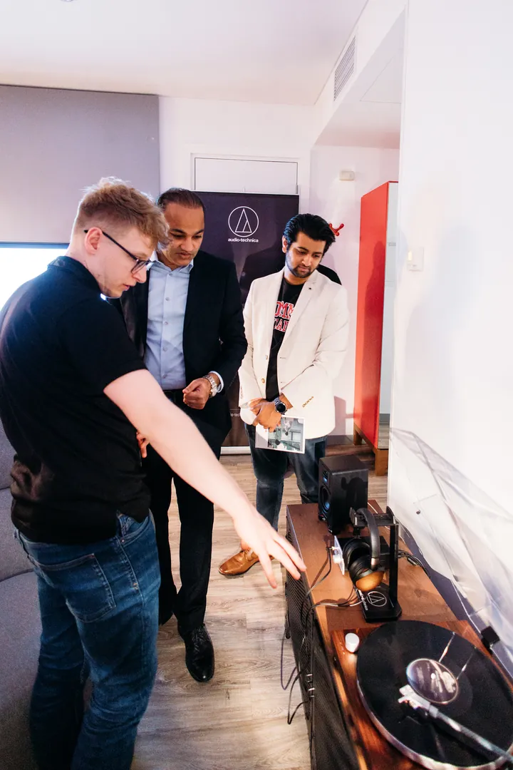 An exhibitor showing a turntable to two guests