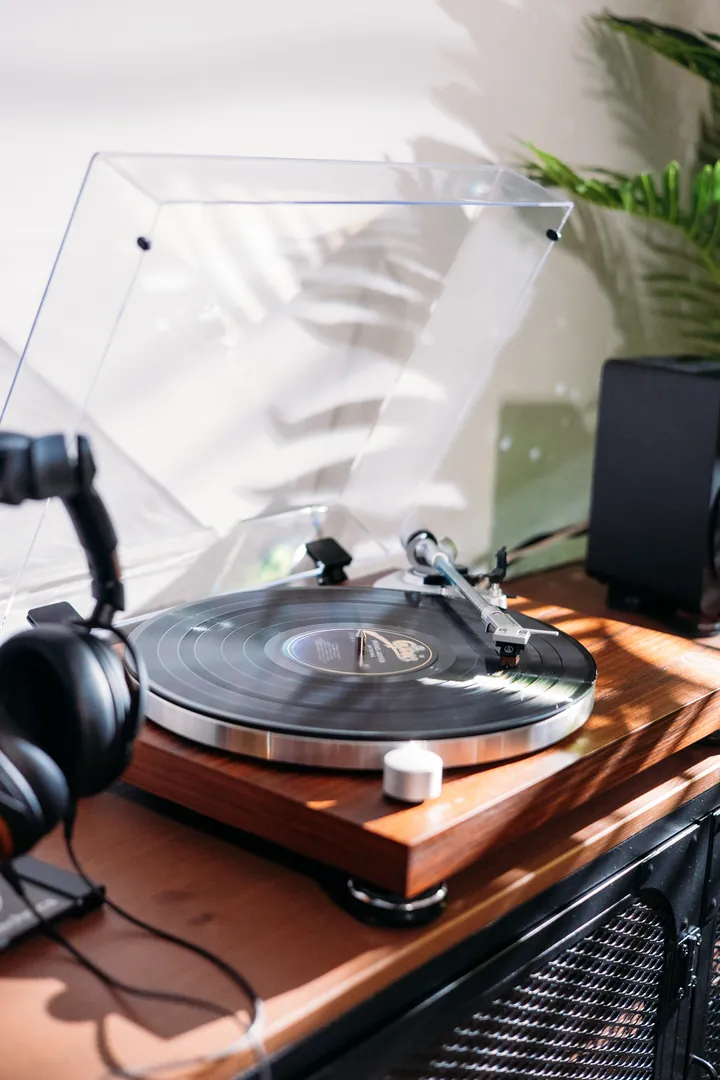 A turntable and headphones on a walnut stand