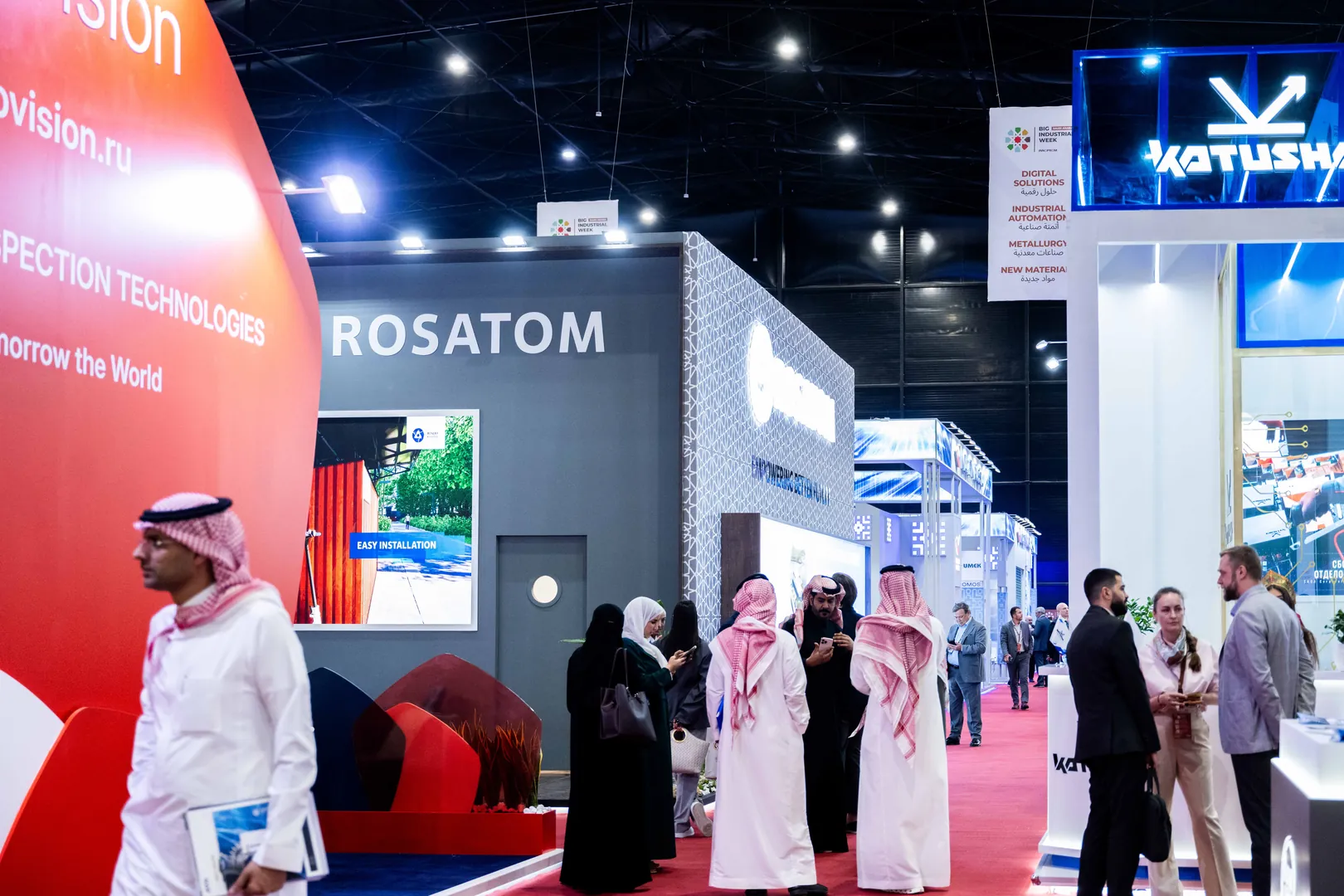 Visitors walking the aisle past the Rosatom stand