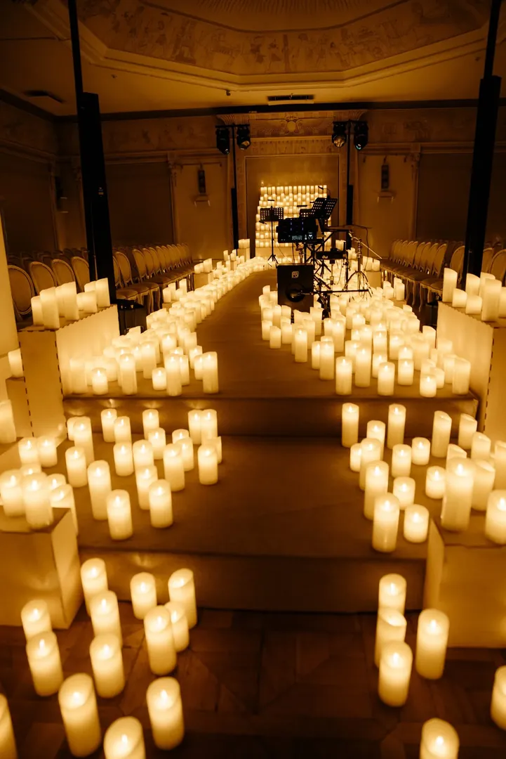 An aisle through rows of candles towards the stage