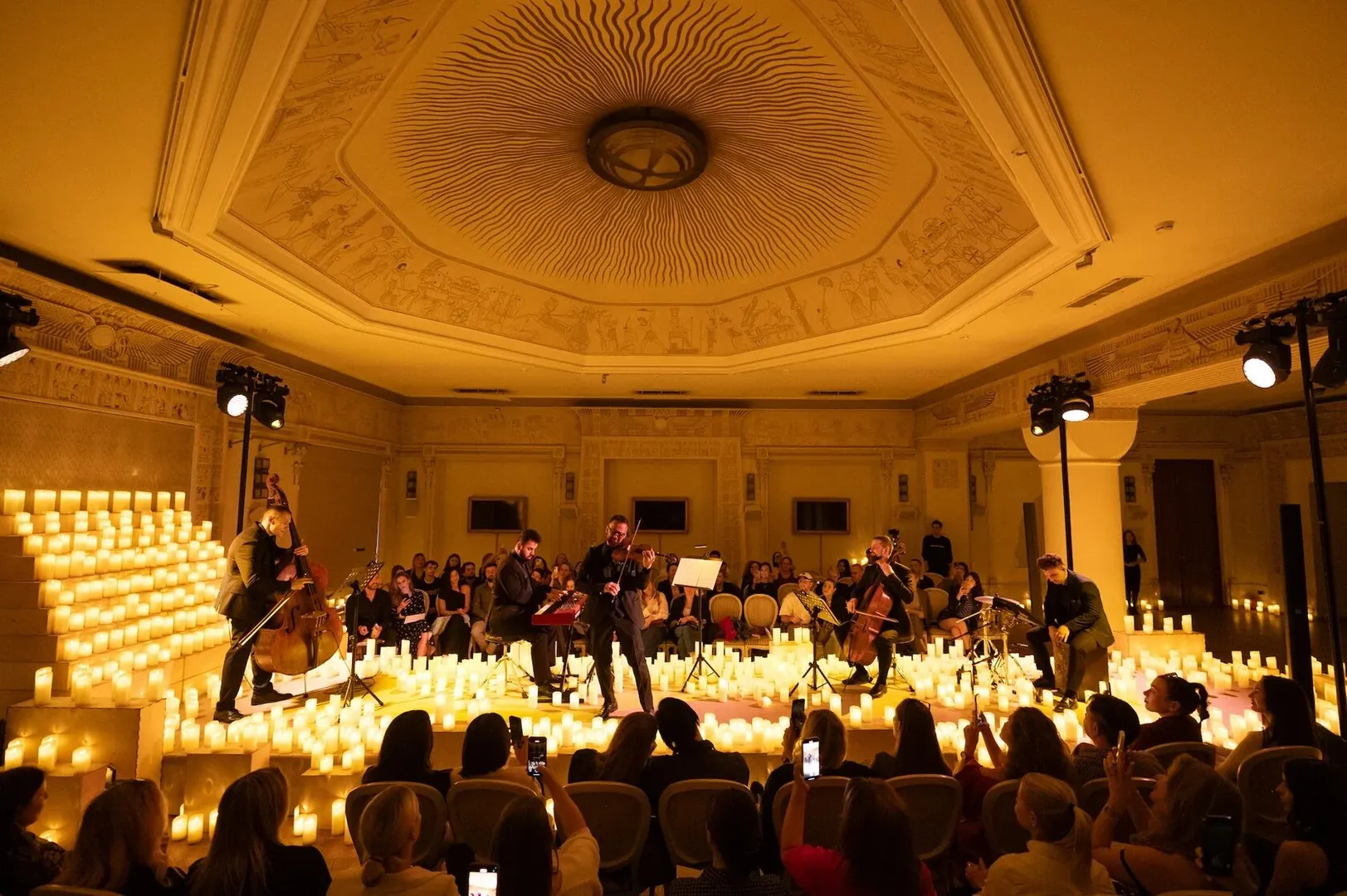 A string ensemble playing to a full hall by candlelight