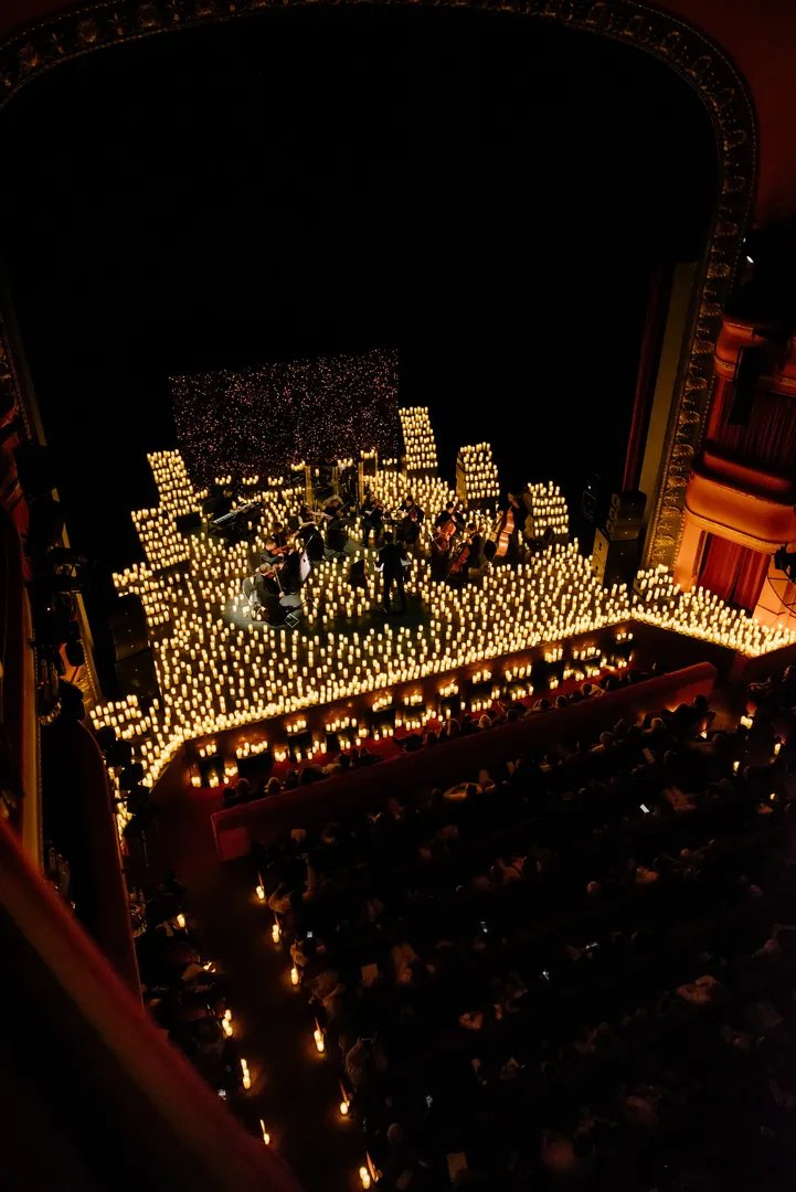 The theatre from the balcony, the stage ringed with candles