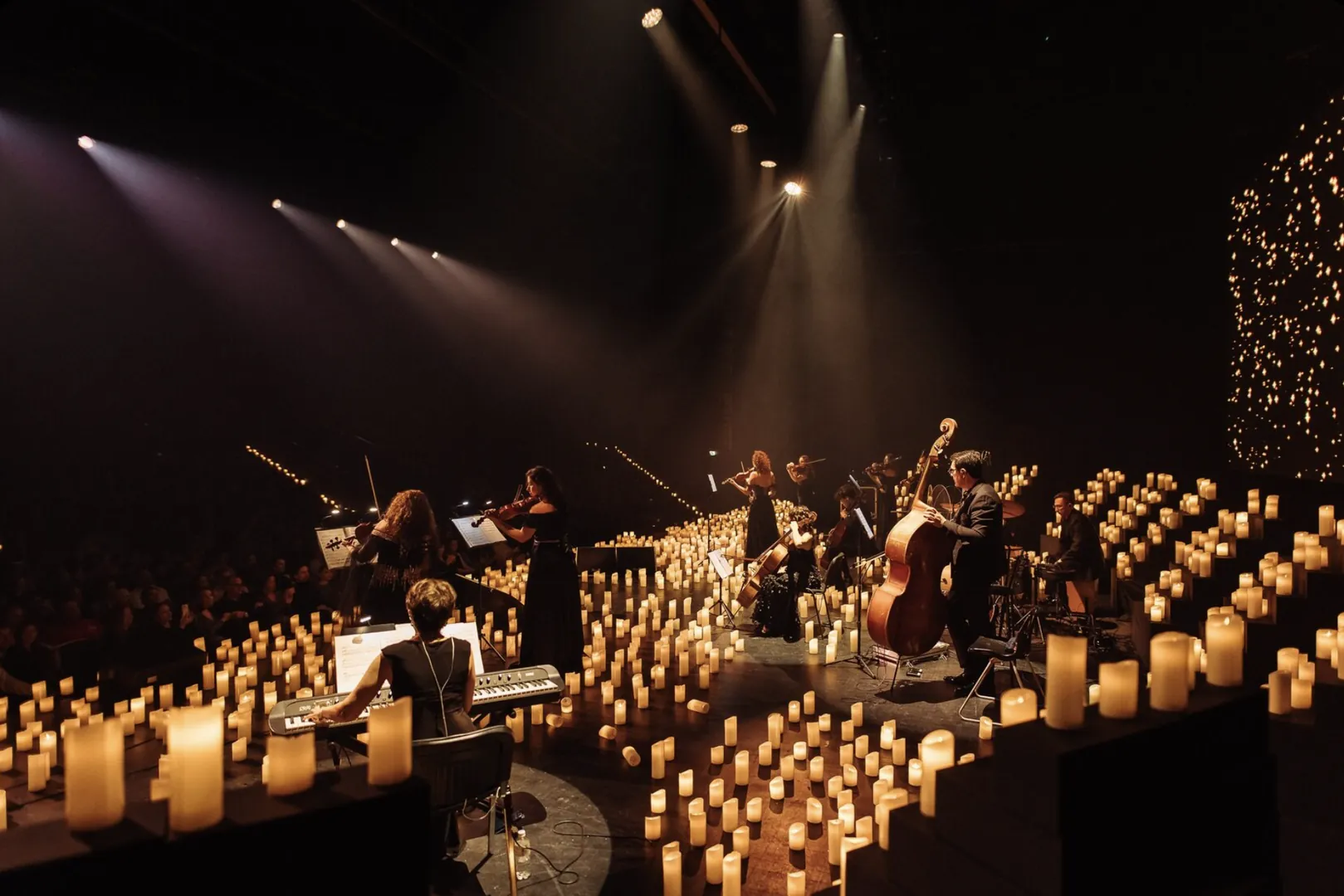 Spotlights over the musicians and the candles