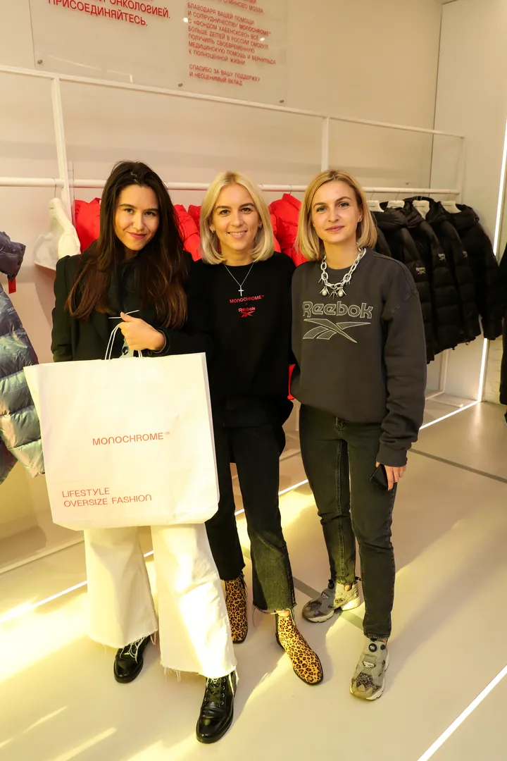Guests at the store launch holding a branded bag