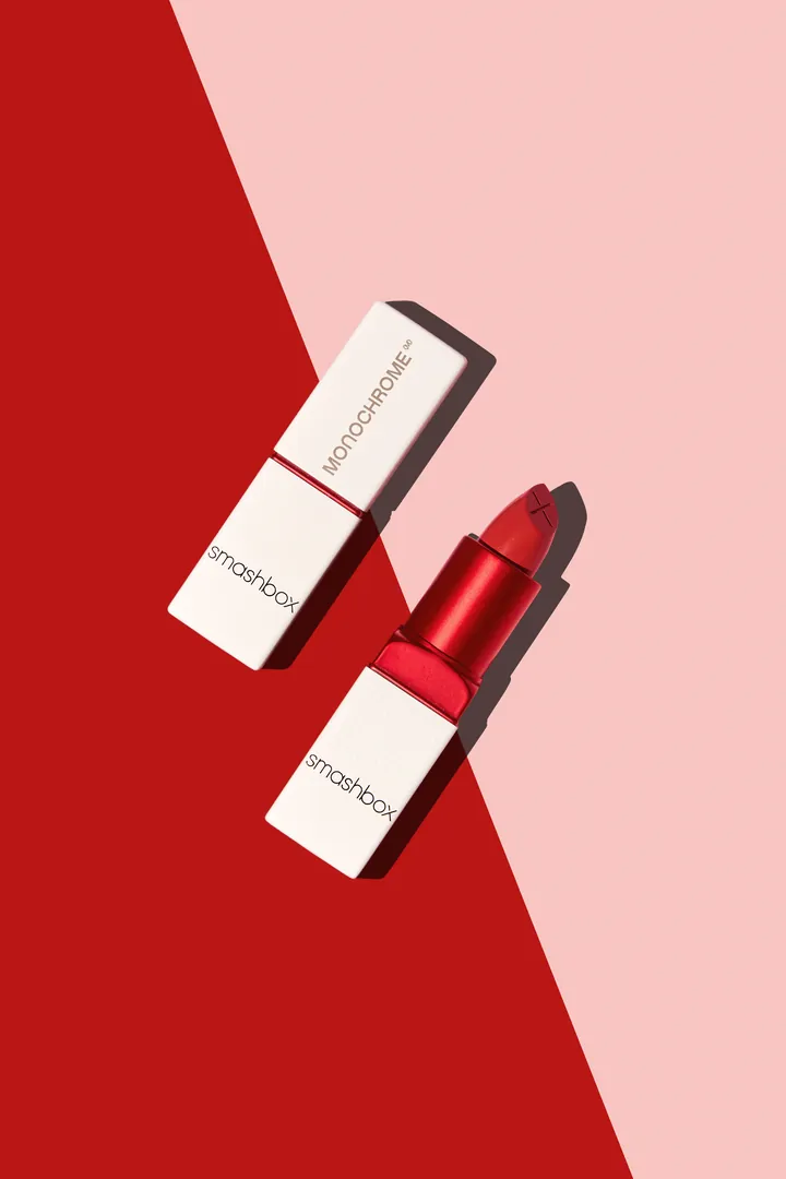 Two lipsticks on a red and pink split background