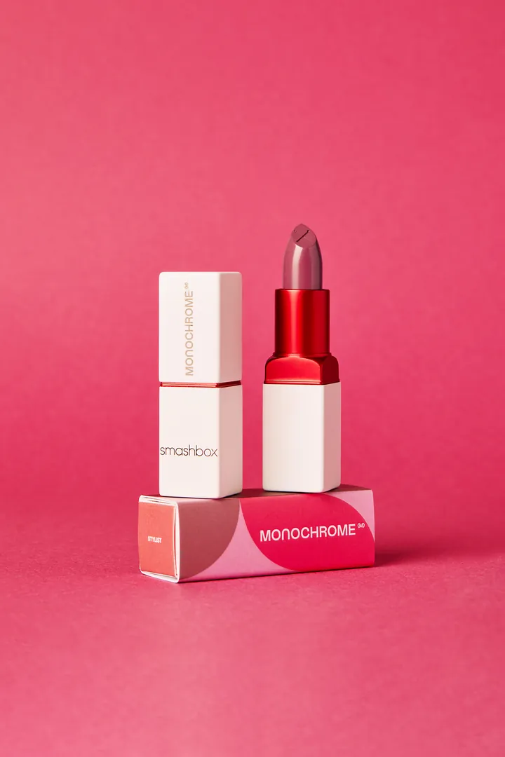 The lipstick and its box on pink