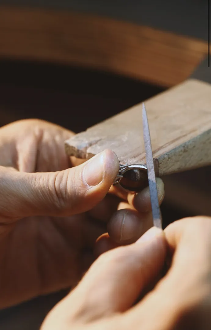 A jeweller filing a ring at the bench