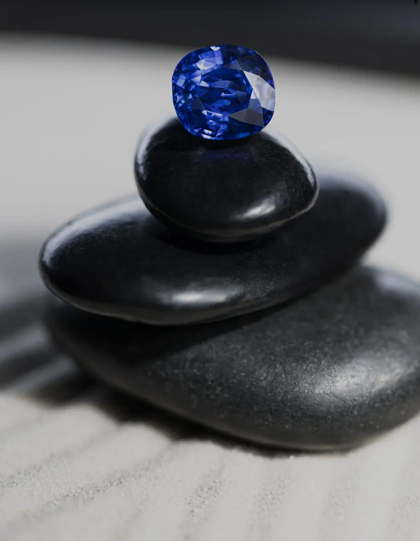 A blue sapphire balanced on black stones