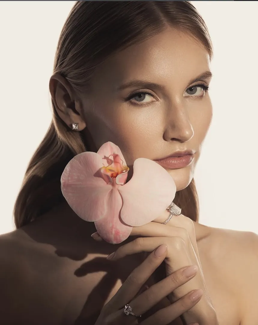 A model holding a pink orchid, wearing Niobim rings