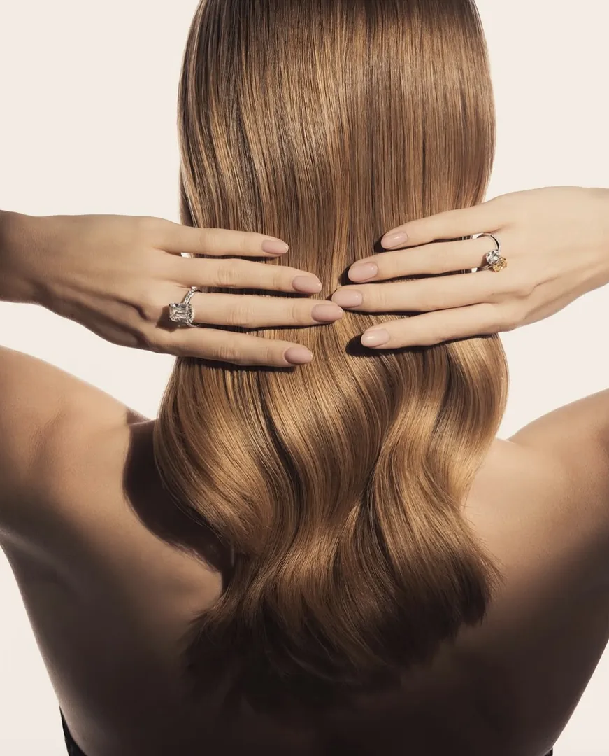 Hands with Niobim rings resting on long hair