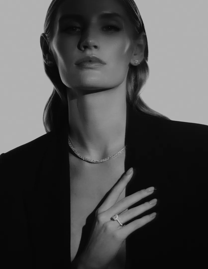 A black-and-white portrait with a ring and a fine necklace