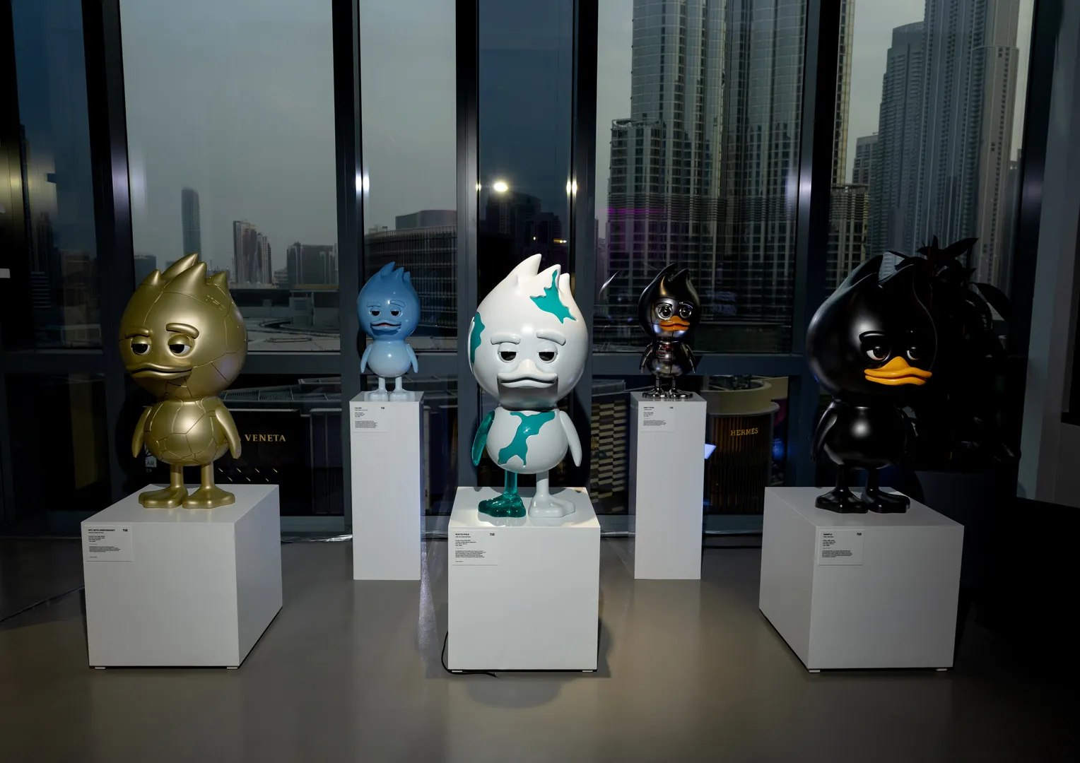 TUD TOY art figures on plinths before the Dubai skyline