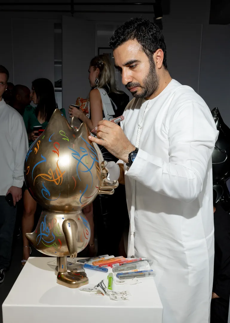 An artist painting a TUD figure during the opening